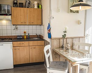 Compacte keuken in Bungalow 9708, De Koog, Texel met houten kasten en eetgedeelte.