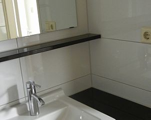 Wastafel met spiegel in de badkamer van Vakantiehuis 1, De Koog, Texel.