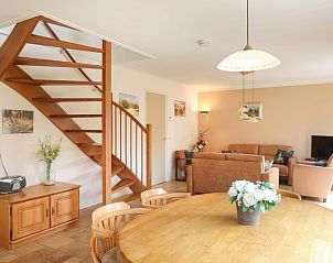 Ruime woonkamer in Bungalowpark 't Luwe Land - Vakantiehuis 7A, De Koog, Texel, met houten trap.