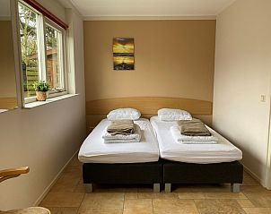 Slaapkamer met tweepersoonsbed in Bungalowpark 't Luwe Land - Vakantiehuis 7A, De Koog, Texel, met serene sfeer.