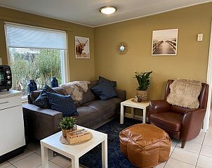 Comfortabele zithoek in Bungalow 51, Bungalowpark 't Luwe Land, De Koog, Texel, met leren fauteuil.
