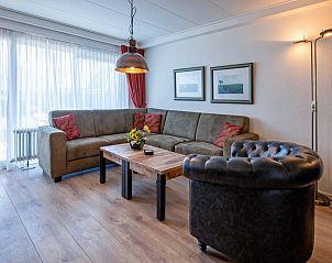Knusse zithoek in Appartementen Anna - de Zeehond, De Koog, Texel met een uitnodigende sfeer en comfortabele stoelen.
