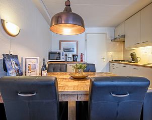 Eetgedeelte in Appartementen Anna - de Zeehond, De Koog, Texel met houten tafel en moderne keukenapparatuur.