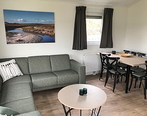 Gezellige woonkamer in Chalet type 4, vakantiehuis in De Koog, Texel. Comfortabele zithoek met uitzicht op de natuur van de Waddeneilanden.