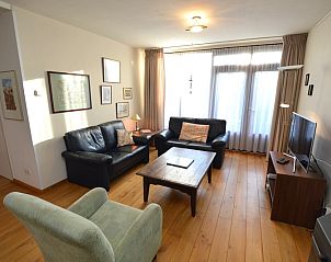 Lichte woonkamer van vakantiehuis Orchismient 35, De Koog, Texel, met grote ramen.