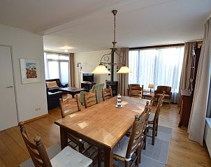 Eetgedeelte in vakantiehuis Orchismient 35, De Koog, Texel, met houten tafel en stoelen.