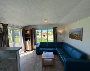 Gezellige woonkamer in Chalet type 3, een vakantiehuis in De Koog, Texel. Geniet van comfort met uitzicht op de groene omgeving van de Waddeneilanden.