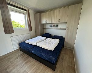 Slaapkamer in Chalet type 3, De Koog, Texel, met comfortabel tweepersoonsbed en natuurlijk licht, ideaal voor een ontspannen vakantie.