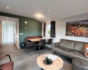 Gezellige woonkamer van Chalet type 1 in De Koog, Texel. Comfortabele zitruimte en eethoek voor ontspannen vakantieverblijf op de Waddeneilanden.