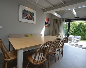 Eetkamer in Ruijslaan 73 De Koog Texel met houten tafel en directe toegang tot terras.