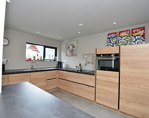 Stijlvolle keuken in Ruijslaan 73 De Koog Texel met houten kasten en moderne apparatuur.