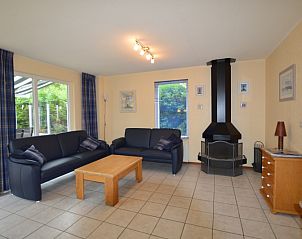 Gezellige woonkamer van Vakantiehuis Stappeland 111 in De Koog, Texel met comfortabele zithoek en open haard.