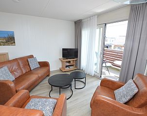 Ruime woonkamer met toegang tot het balkon in Motel Texel - Appartement 208/1L, De Koog, Texel. Perfect voor een vakantie op de Waddeneilanden.