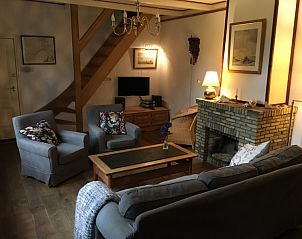 Knusse woonkamer van Voorhuis vakantiehuis in De Koog, Texel met open haard en comfortabele zitplaatsen.