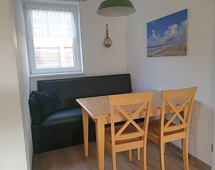 Essecke von De Duinpan - Duinhuisje Texel in De Koog, Texel, mit Holztisch und bequemem Sofa.
