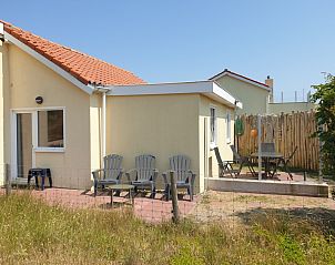 Sonnige Terrasse von De Duinpan - Duinhuisje Texel in De Koog, Texel, mit reichlich Sitzgelegenheiten.