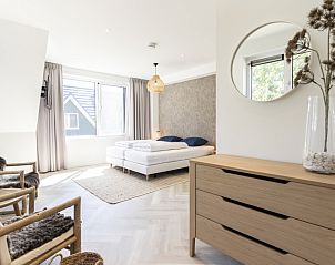 Lichte slaapkamer in Villa 19, De Koog, Texel, met comfortabel bed en gezellige zithoek.