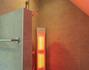 Moderne douche met infraroodlamp in Villa 19, een vakantiehuis in De Koog, Texel.