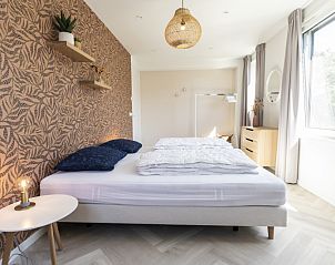 Villa 19 in De Koog, Texel, slaapkamer met unieke wanddecoratie en veel daglicht.