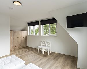 Ruime slaapkamer met grote ramen in Villa 37, vakantiehuis op Texel, Waddeneilanden.