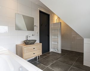 Moderne badkamer met bad en wastafel in Villa 37, gelegen in De Koog, Texel.