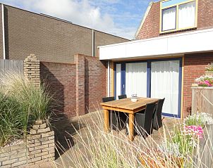 Privterras van Vakantiehuis Koogerduin, De Koog, Texel, met gezellige zithoek en groene planten.