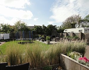 Grote tuin met trampoline en zitjes bij Vakantiehuis Koogerduin, De Koog, Texel, voor buitenplezier.
