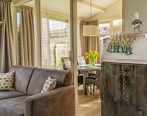 Open woonkamer en eetruimte in De Anemoon, De Koog, Texel. Gezellige inrichting met veel lichtinval.