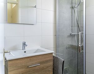 Moderne badkamer in vakantiehuis De Anemoon, De Koog, Texel. Stijlvolle douche en wastafel met houten afwerking.