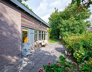 Veranda van De Zonneweelde vakantiehuis in De Koog, Texel met groene omgeving.