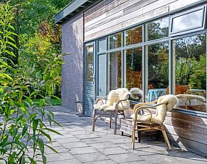 Zonnig terras bij De Zonneweelde vakantiehuis in De Koog, Texel, omringd door natuur.