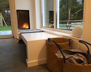 Gezellige haardhoek in Buitenduin vakantiehuis, De Koog, Texel met uitzicht op de tuin.