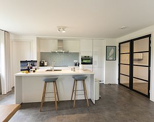 Functionele keuken in Buitenduin, De Koog, Texel met barstoelen en veel lichtinval.