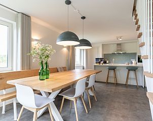 Ruime eetkamer in Buitenduin, De Koog, Texel met houten tafel en moderne lampen.