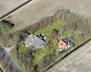 Luchtfoto van vakantiehuis Achterhuis in De Koog, Texel, met ruime groene omgeving.