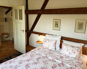 Sfeervolle slaapkamer met houten balken in vakantiehuis Achterhuis, De Koog, Texel.