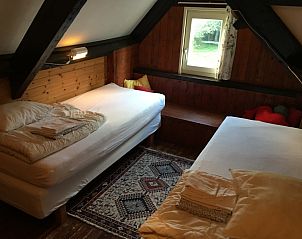 Knusse tweepersoonskamer in vakantiehuis Achterhuis, De Koog, Texel, met houten interieur.