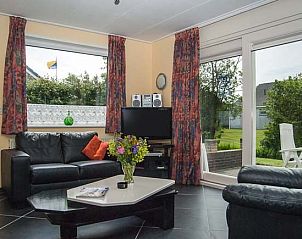 Lichte woonkamer in De kemphaan: Vakantiehuis Texel, De Koog, met uitzicht op de tuin, ideaal voor ontspanning.