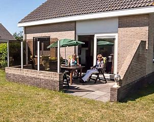 Zonnig terras van De kemphaan: Vakantiehuis Texel, De Koog, perfect voor buiten dineren en genieten van de natuur.