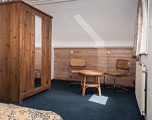 Slaapkamer in De kemphaan: Vakantiehuis Texel, De Koog, met houten meubels voor een rustieke uitstraling op de Waddeneilanden.