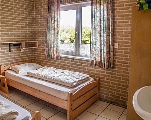 Knusse slaapkamer met twee bedden in De kemphaan: Vakantiehuis Texel, De Koog, ideaal voor een comfortabel verblijf.