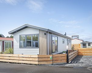 Chaletpark Bregkoog - Chalet Bregkoog 262 in De Koog, Texel, a modern vacation home with wooden terrace and fence.