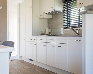 Modern kitchen in Chalet Bregkoog 262, De Koog, Texel, with sleek white cabinets and cooktop.
