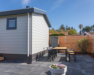 Sunny terrace at Chalet Bregkoog 262, De Koog, Texel, with outdoor furniture and enclosed garden.