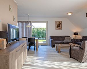 Comfortabele woonkamer in Villa 4, De Koog Texel, met uitzicht op de tuin voor ontspanning op de Waddeneilanden.