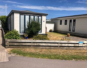 Gemtliches Ferienhaus Chalet Bregkoog 33 auf Texel, gelegen in De Koog, mit einladendem Auenbereich und grner Umgebung.