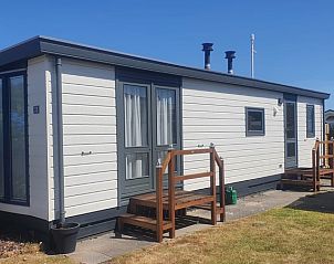 Seitenansicht von Chalet Bregkoog 33 in De Koog, Texel, mit sonniger Veranda und modernem Look fr einen komfortablen Aufenthalt.