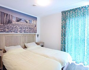 Sfeervolle slaapkamer in Kustpark huizen, De Koog, Texel, met tweepersoonsbed en strandthema decoratie.