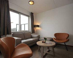 Gezellige zithoek in Landleven 4/5 pers. vakantiehuis, De Koog, Texel, met uitzicht op de natuurlijke omgeving.