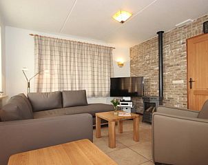 Gezellige woonkamer in 6 Persoons luxe villa met sauna, De Koog, Texel, met comfortabele zithoek en open haard.